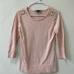 Pink sweater with pearl accents.